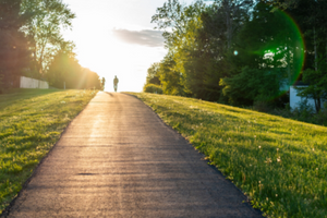 photo of a bike path with two silhouettes in the background