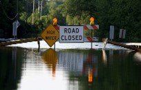 flooding in front of a road closed sign