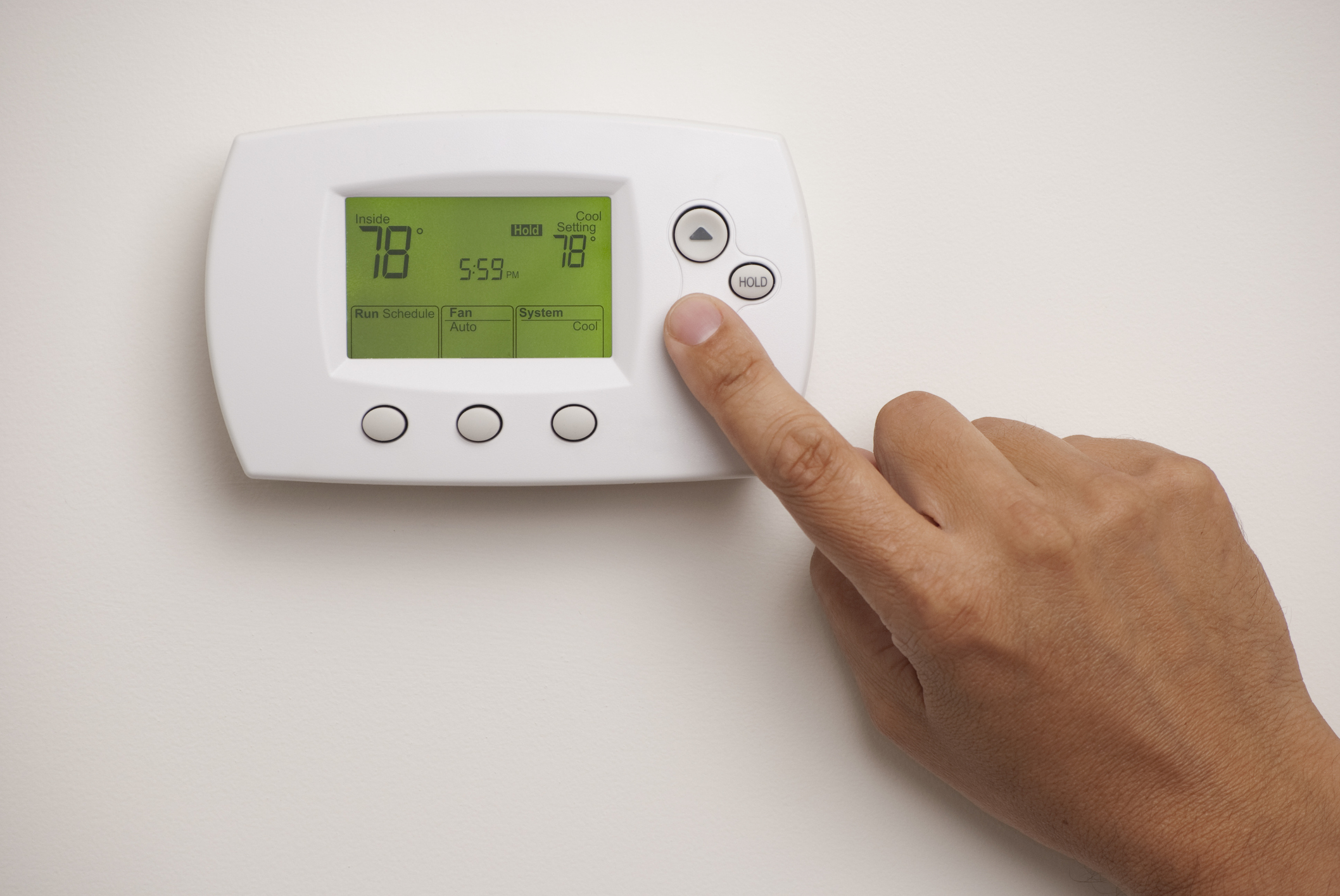 person adjusting a thermostat