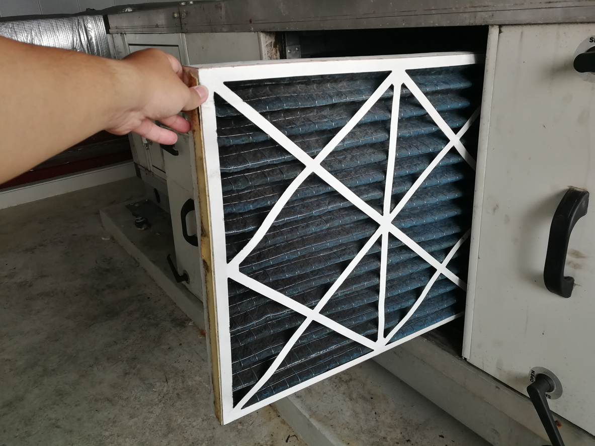 Person checking a filter of air handling unit for replacement a new filter