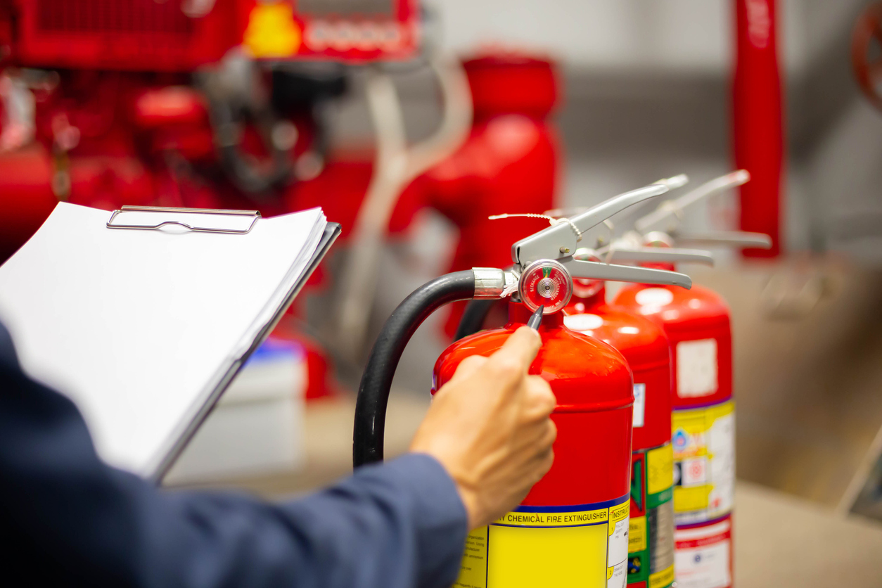 fireman checking a fire extinguisher