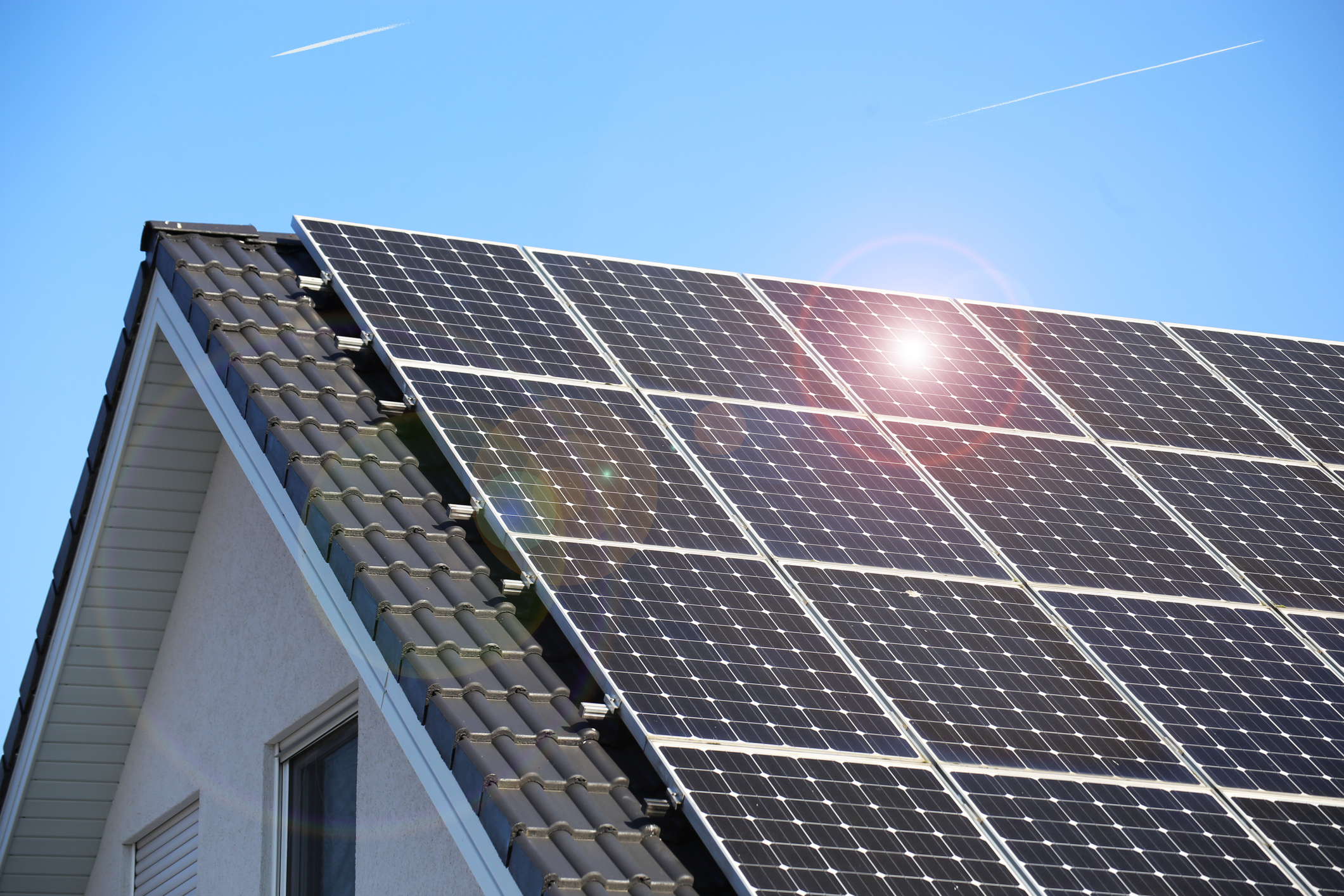 solar panels on a house with sun flare