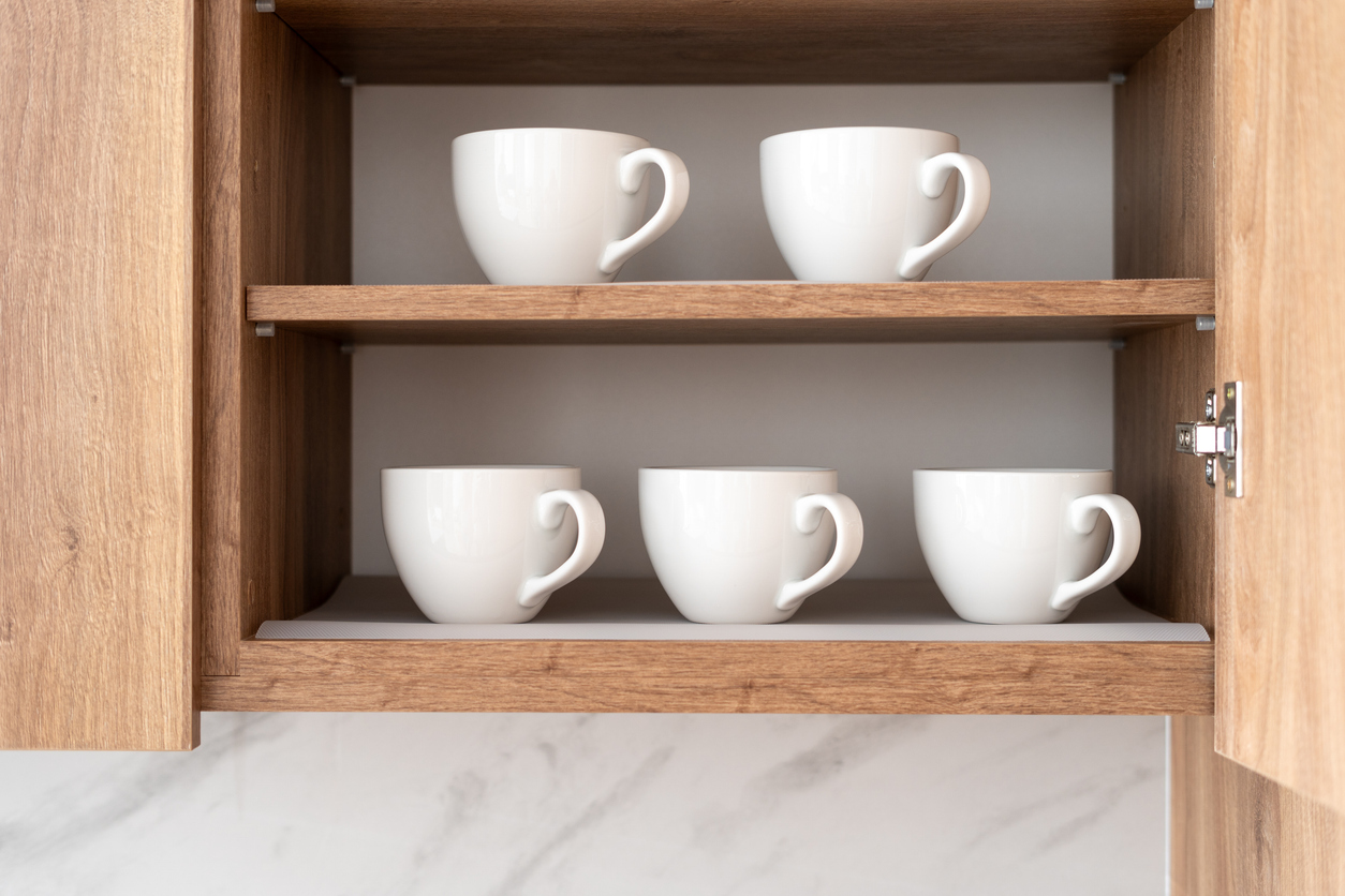 photo of white mugs in a cabinet