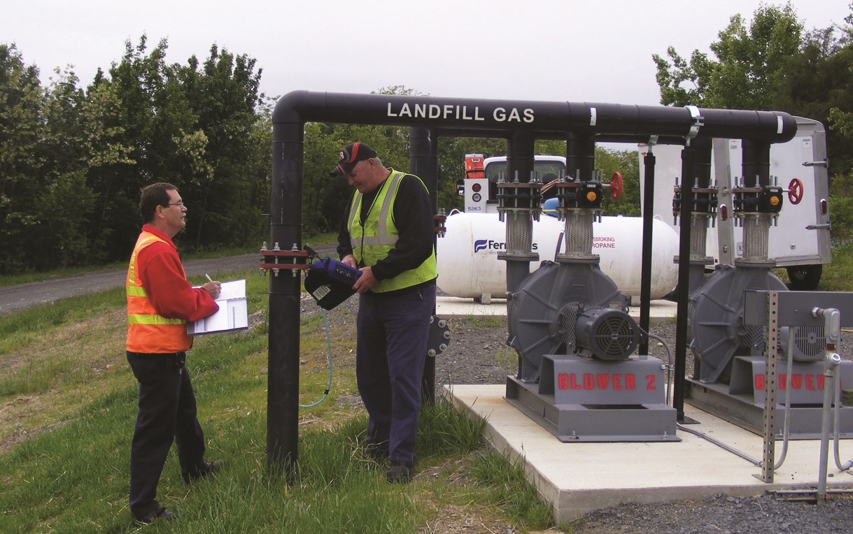 photo of two men standing near a landfill gas station