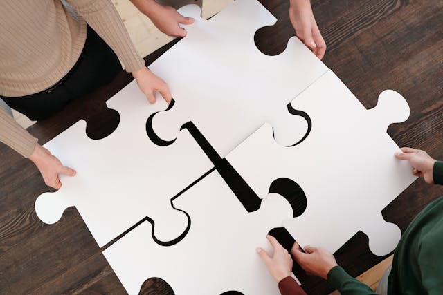 people holding puzzle pieces