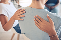 hands on person's back in support