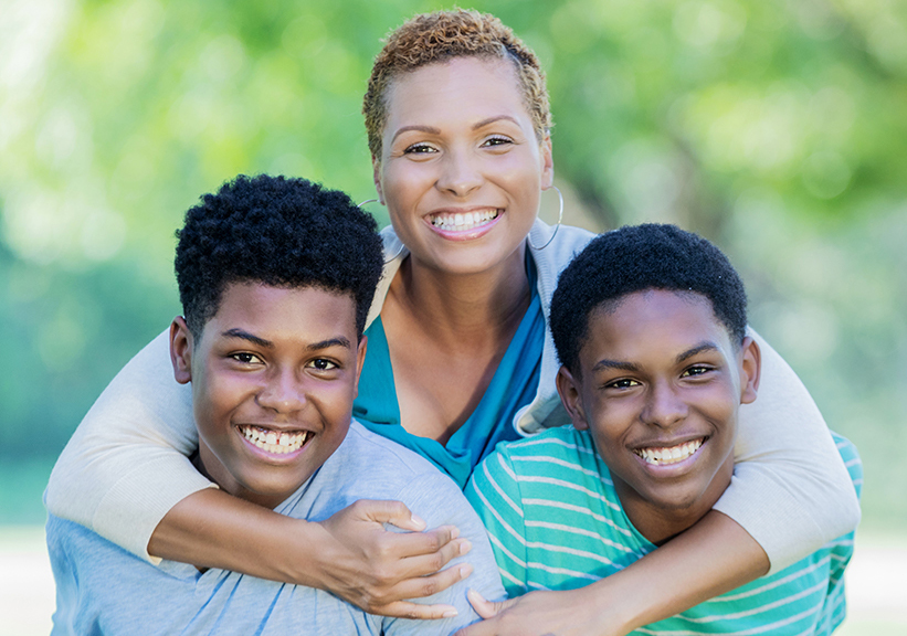 adult and two children hugging outside