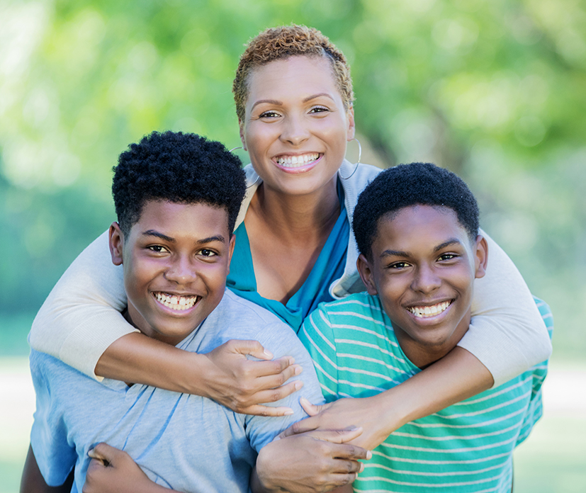 adult and two children hugging outside