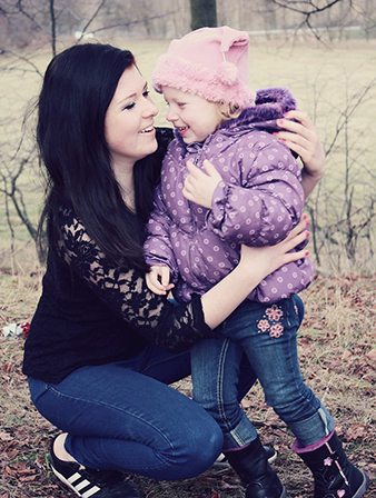 adult outside kneeling and hugging young child