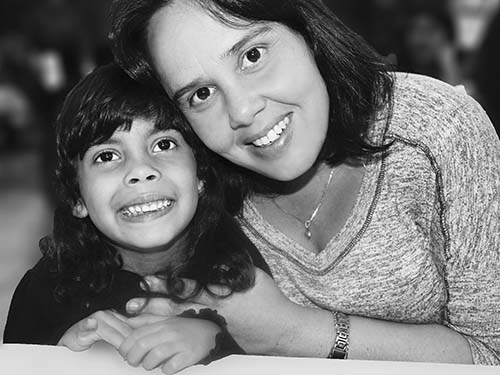 adult and child sitting closely and smiling, black and white photo
