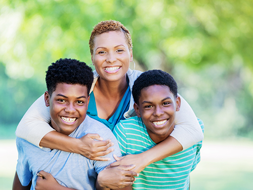 adult and two children hugging outside