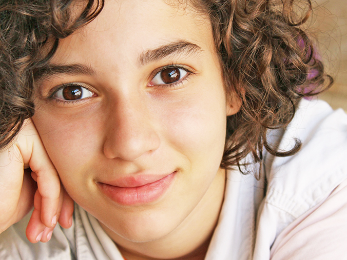 child smiling resting cheek in hand