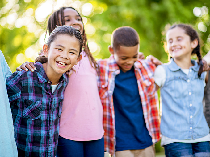 four children stand side by side smiling