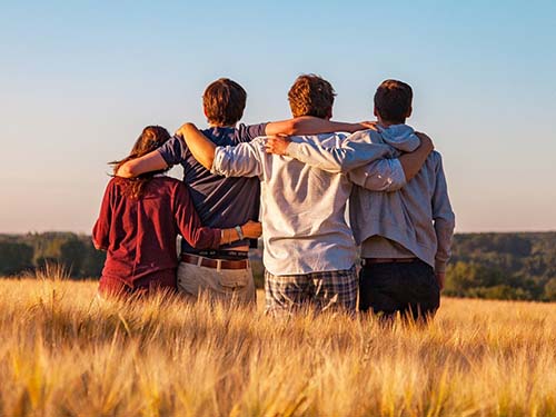 four young people standing shoulder to shoulder