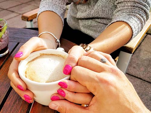 hands holding mug on wood table