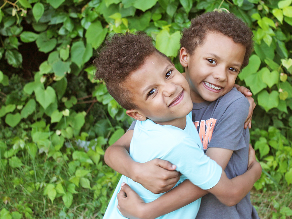 twins outside hugging and smiling