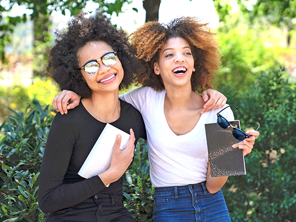 two people hugging and each holding a book