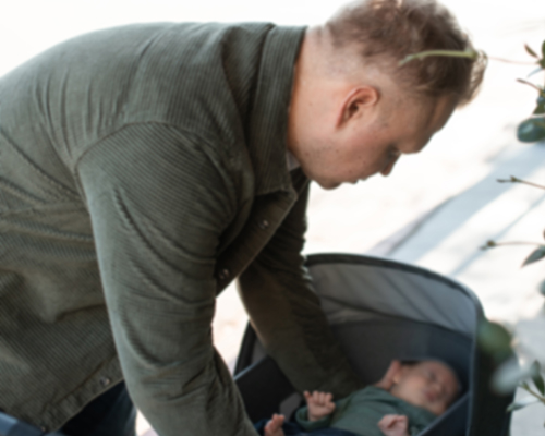 dad putting baby in stroller