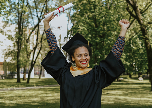 graduate with arms raised