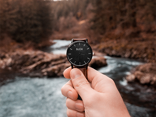Hand holding watch in nature