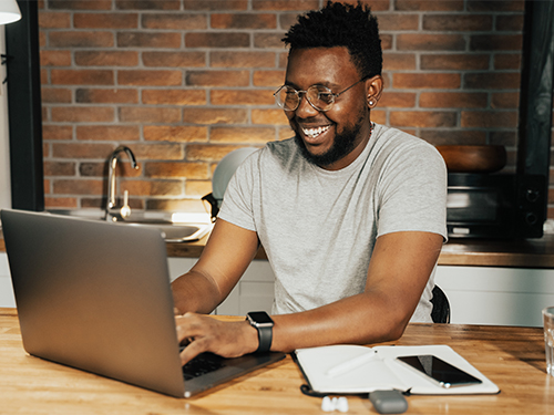 smiling man using laptop