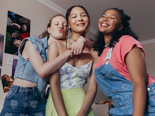 three teen girls hugging