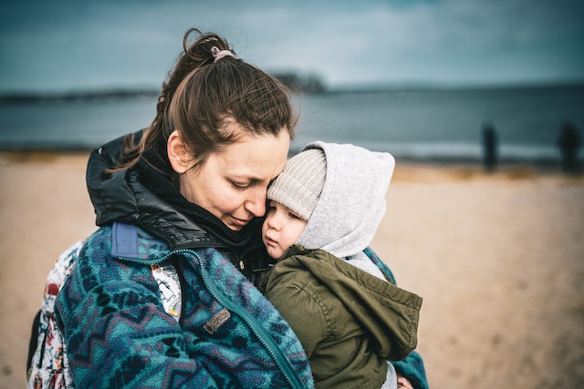 Woman Hugging Child on Beach