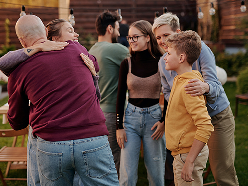 family sitting outside hugging