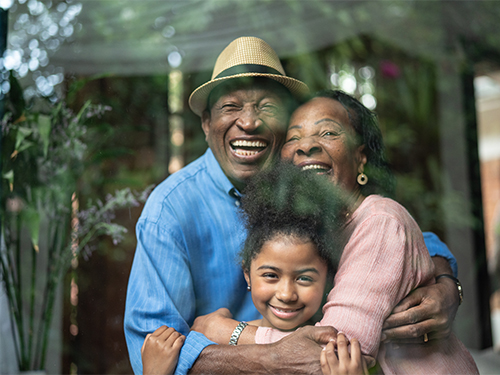 happy older couple hugging girl