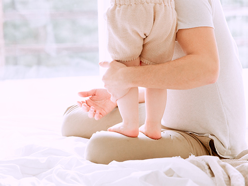 toddler standing on adult's lap