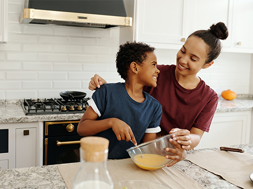Woman and Boy in kitchen cooking smiling 