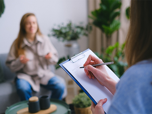 woman therapist taking notes on clipboard