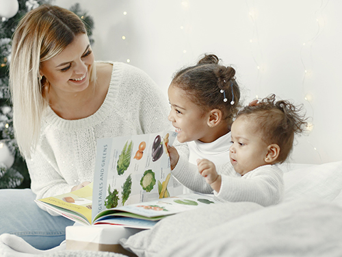 woman and two children reading 