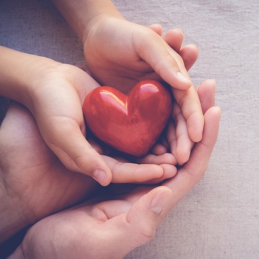adult and child hands holding a heart