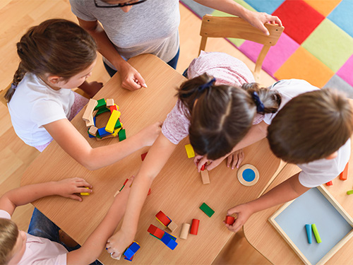 overhead view of children playing with blocks at daycare