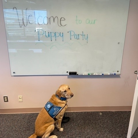 Rylynn sitting in front of Welcome sign