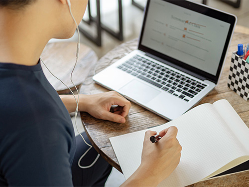 teen boy with laptop and notebook