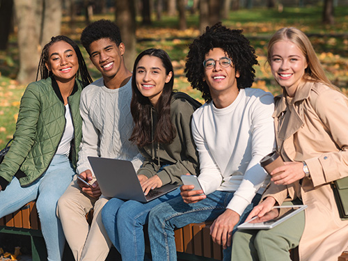 five teens sitting outside