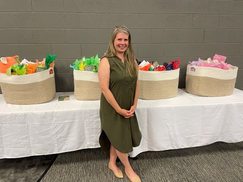 tamie tanner standing in front of gift baskets