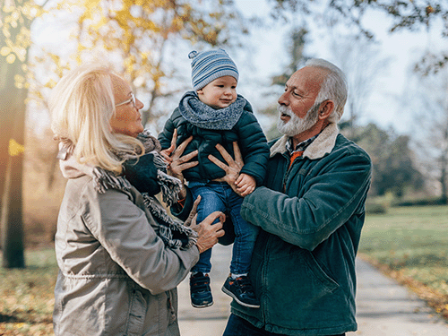 grandparents holding up grandchild