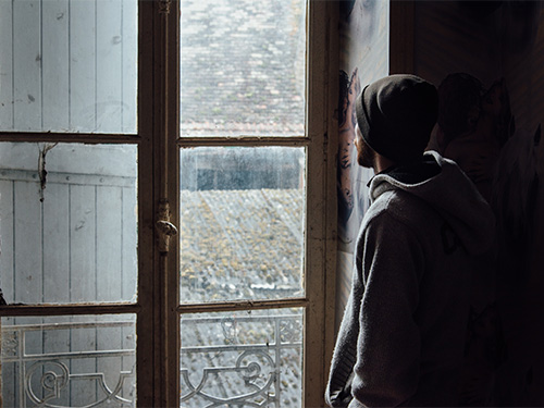 homeless youth looking out window