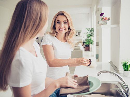 woman and teen girl washing dishes