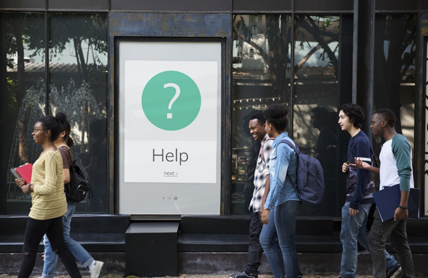 students walking past help sign