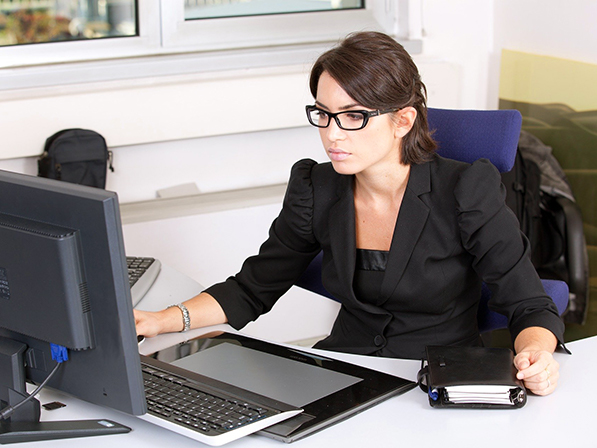 person sitting at desk looking at computer