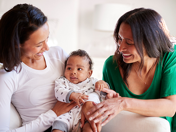 adult looking at parent holding a baby