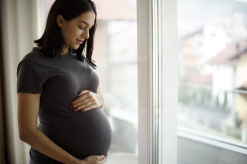 pregnant woman looking down at stomach