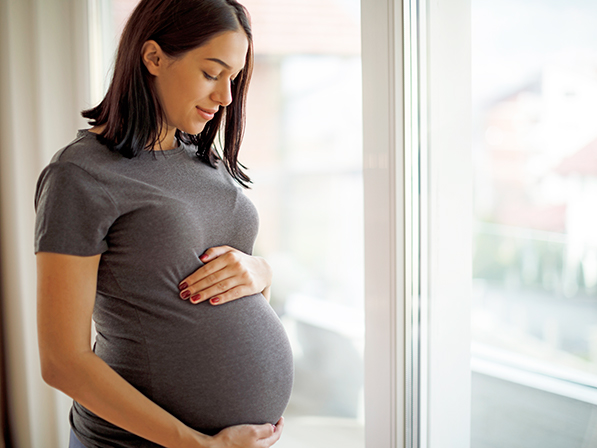 pregnant woman looking at stomach