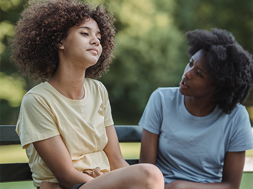 Teen sitting with mom outside