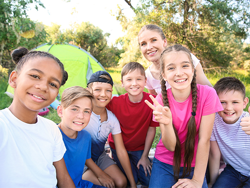 group of tweens with tent and adult