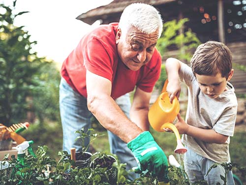older adult gardening with young child